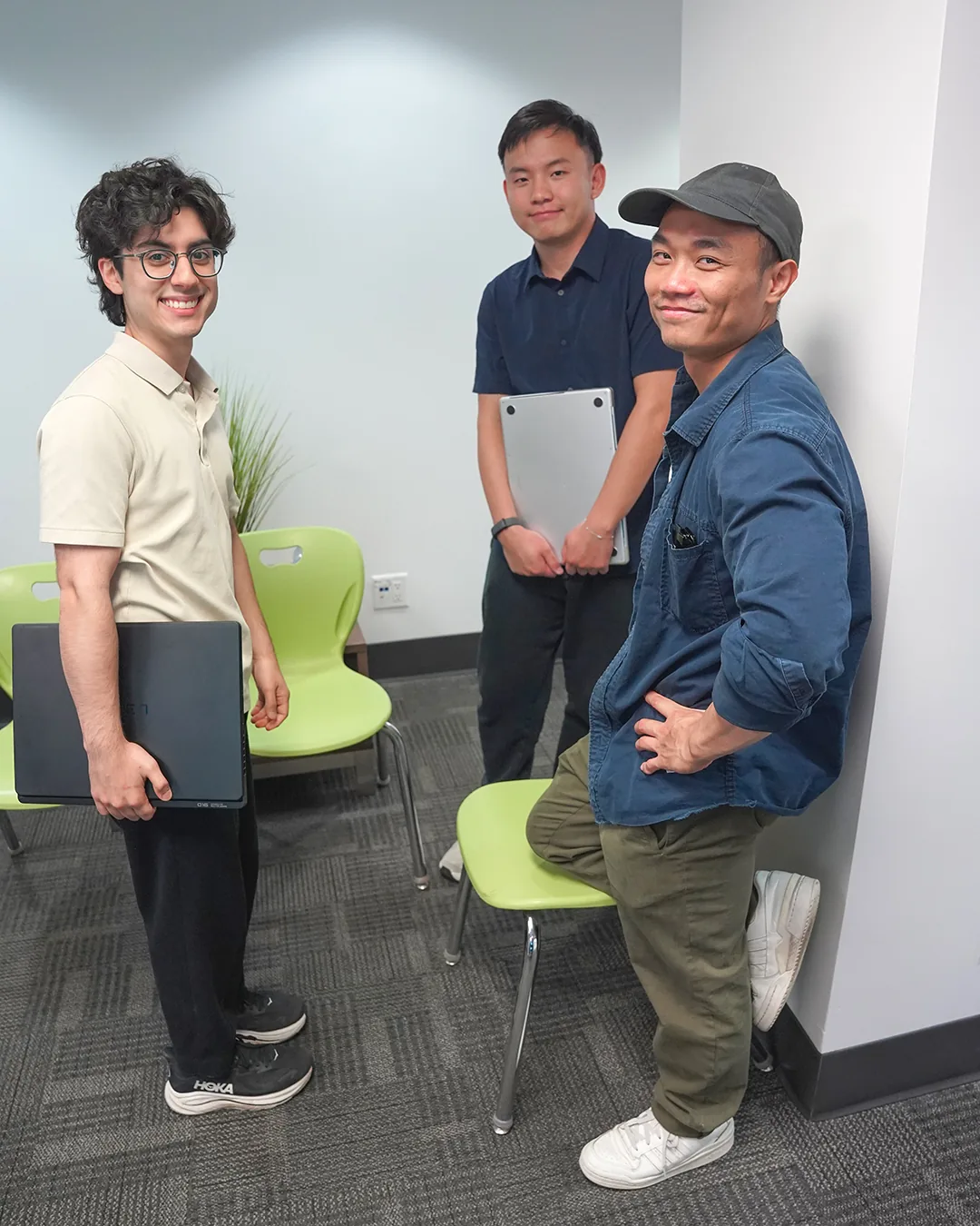 Three participants celebrating with their laptops